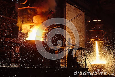 Ingot casting, metal sparks. Ladle-furnace. Iron smelting, Steel production. Stock Photo